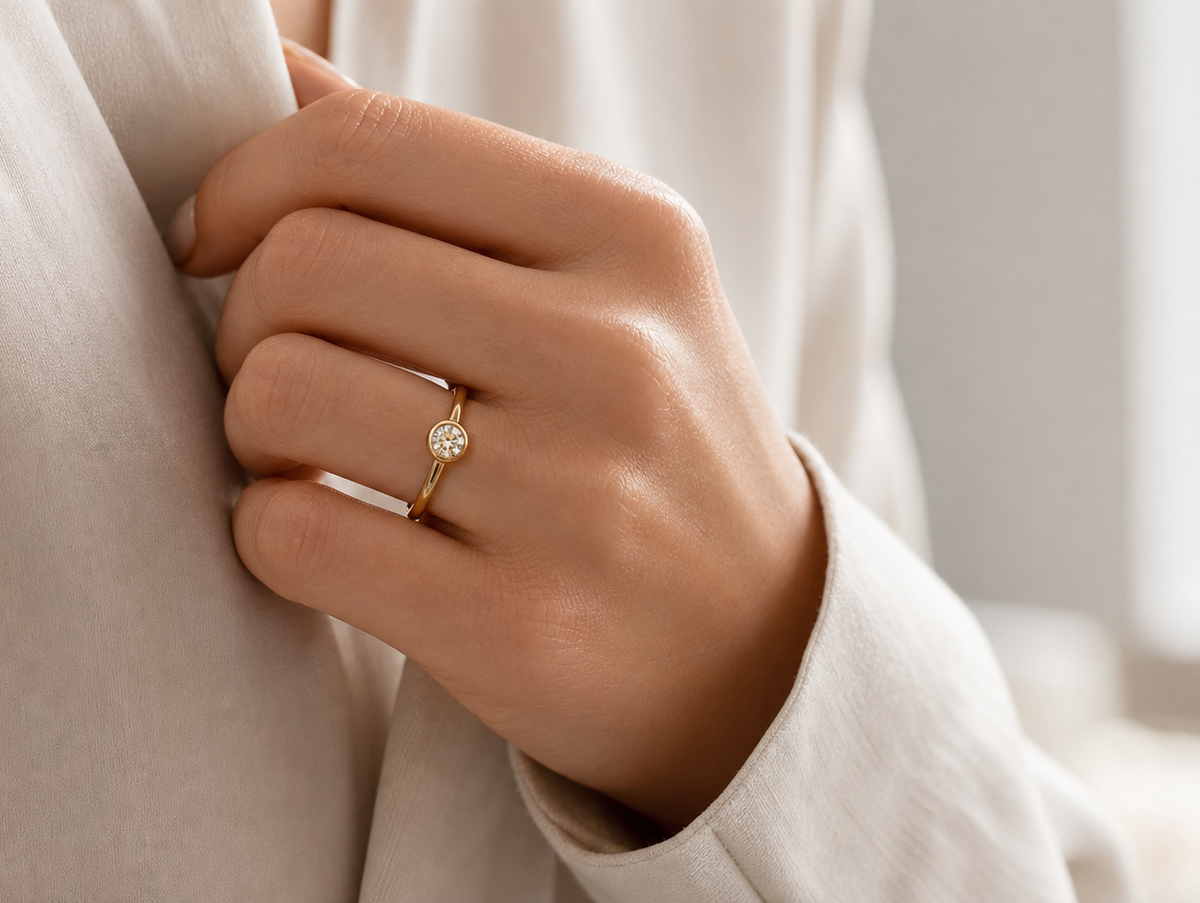 Bezel-set diamond ring worn with a smooth low-profile edge in a refined daily style scene.
