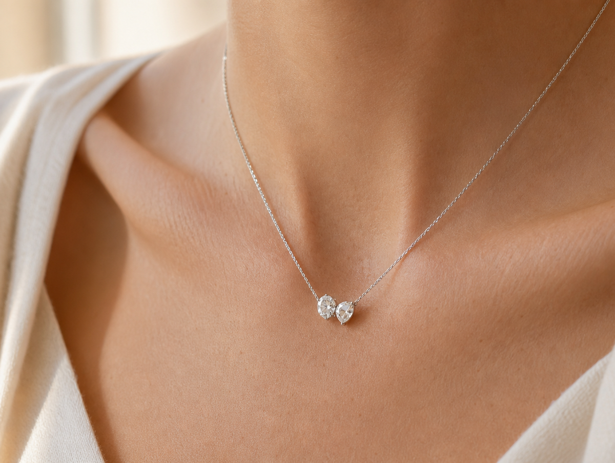 Toi et Moi necklace with two diamond-style stones worn at the collarbone in soft natural light.