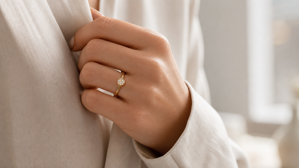 Bezel-set diamond ring worn with a smooth low-profile edge in a refined daily style scene.