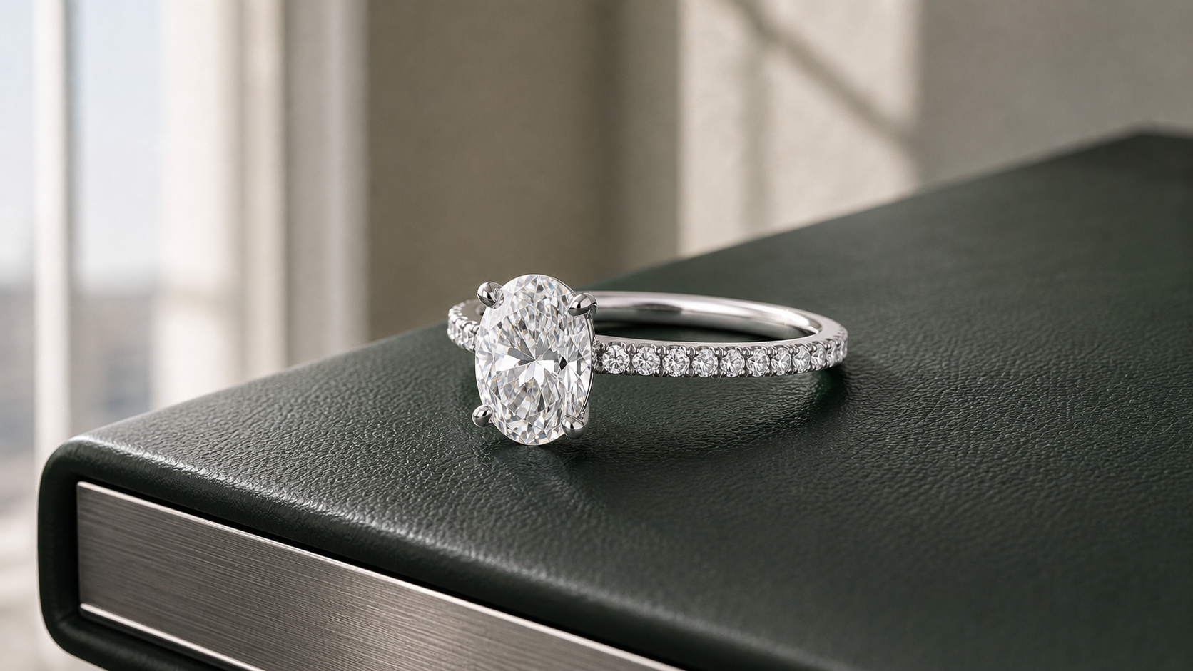 Oval diamond engagement ring with a slim pavé band on a dark green design portfolio.