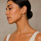Fiorella Emerald Accented Drop Huggie Hoop Lab-Grown Diamond Earrings in 14K Yellow Gold, worn on ear